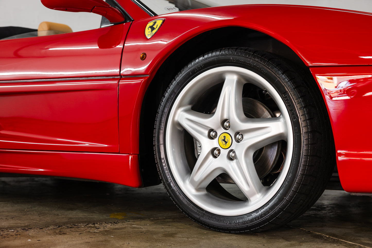 Close-up of a red Ferrari car wheel with visible logo