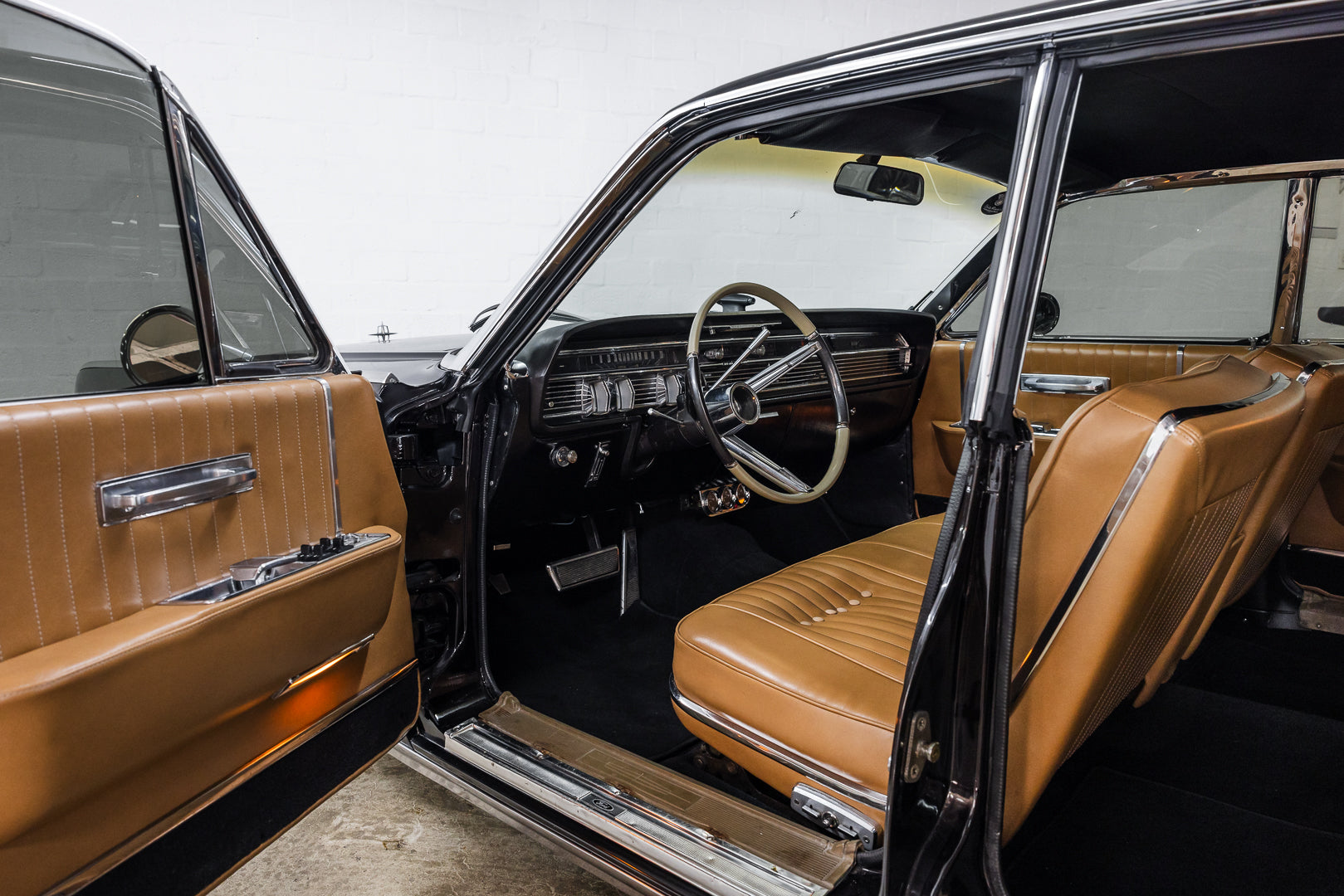 Interior of a classic car with brown leather seats and dashboard.