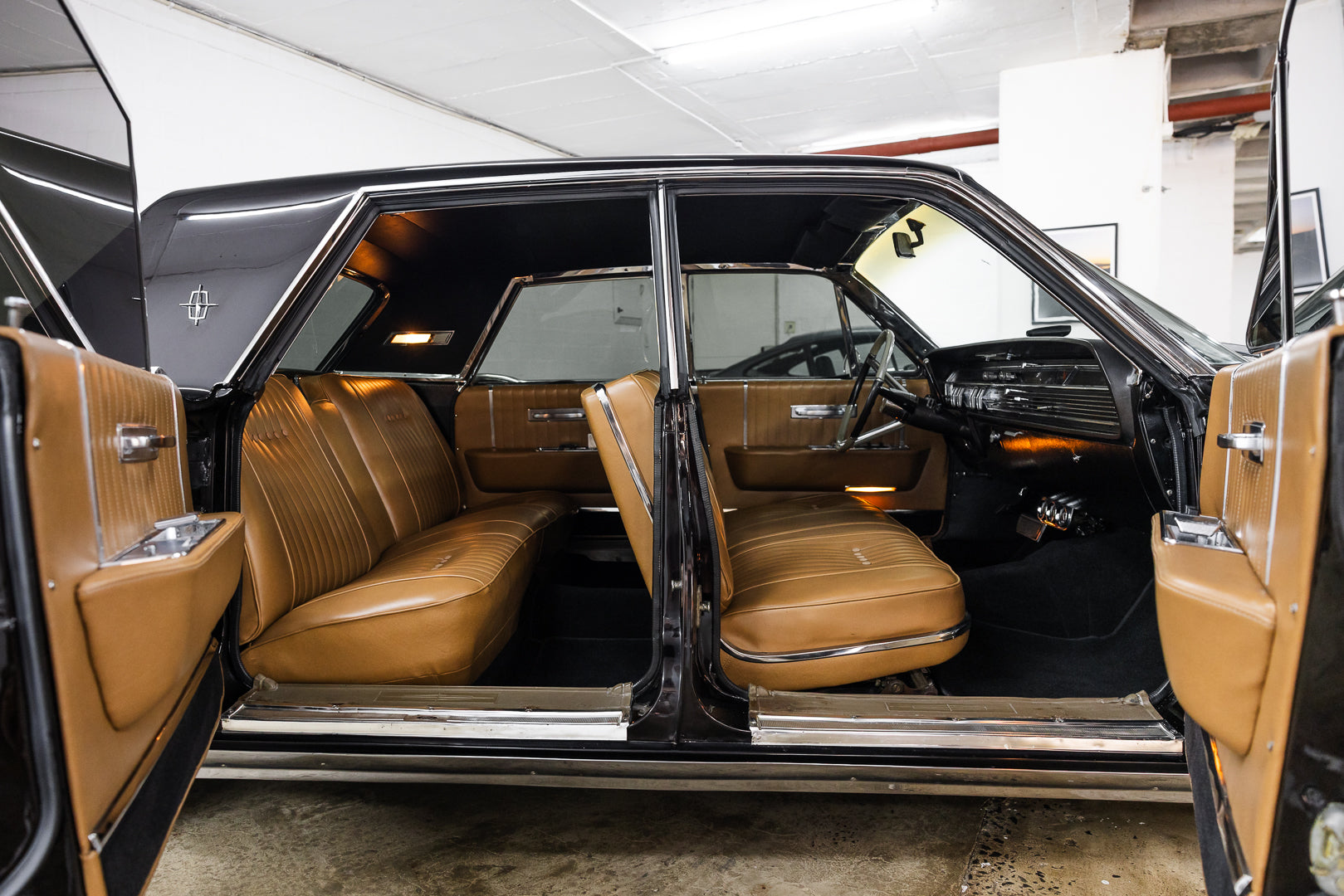 Interior of a classic car with brown leather seats in a garage setting